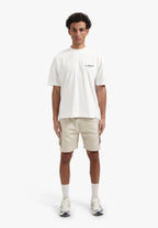 Person wearing a white t-shirt and beige shorts on a white background