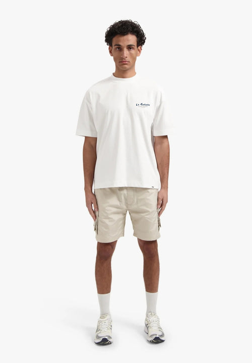 Person wearing a white t-shirt and beige shorts on a white background