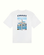 White t-shirt with a graphic design of a beach scene and 'Cannes' text on a white background