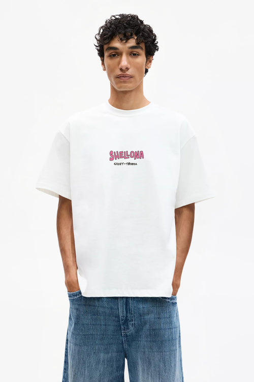 Person wearing a white t-shirt with text and blue jeans on a white background